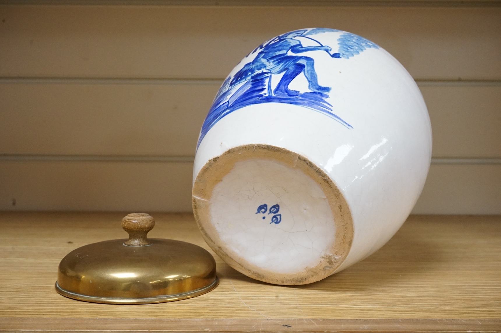 A pottery blue and white figural drug jar with brass cover, 24cm including cover.